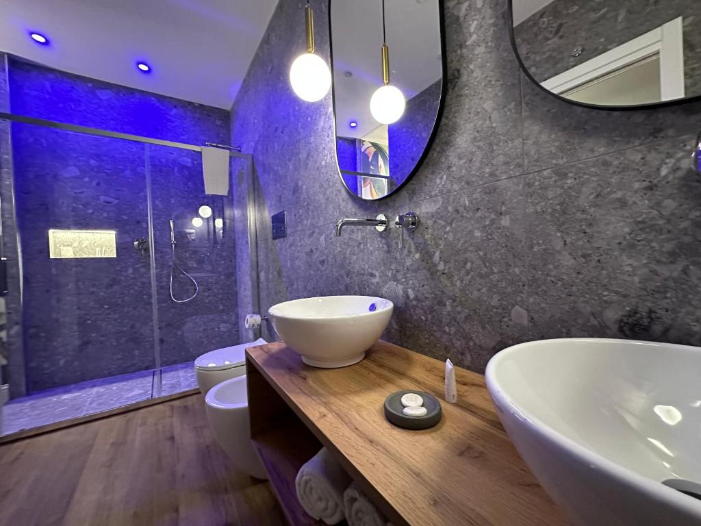 a bathroom with a sink and a toilet and a mirror at Krysos Luxury Rooms in Agrigento