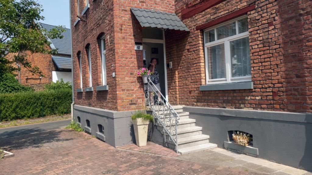 a person standing in the door of a brick house at Schöne Ferienwohnung am nordwestlichen Rand des Taunus in Hünfelden