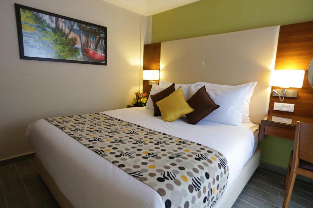 Postel nebo postele na pokoji v ubytování Astral Village Hotel