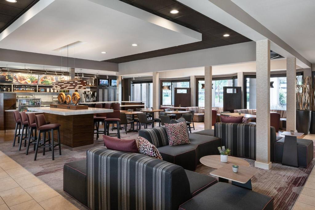un vestíbulo con sofás y mesas y un bar en Courtyard by Marriott Pleasanton en Pleasanton