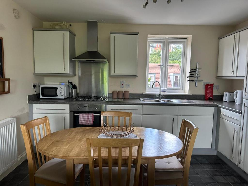 a kitchen with a table and chairs and a kitchen with a sink at Cosy 2 Bedrooms 2 Bathrooms in Basingstoke