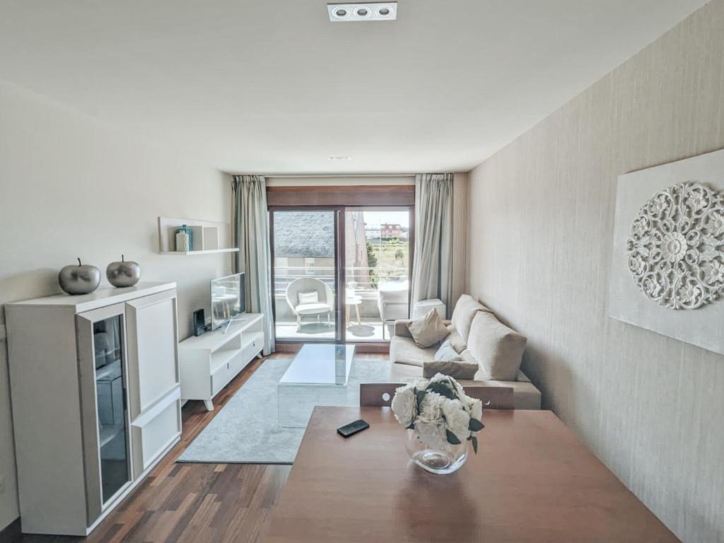 uma sala de estar com um sofá e uma mesa em Apartamento Decanelas em Sanxenxo