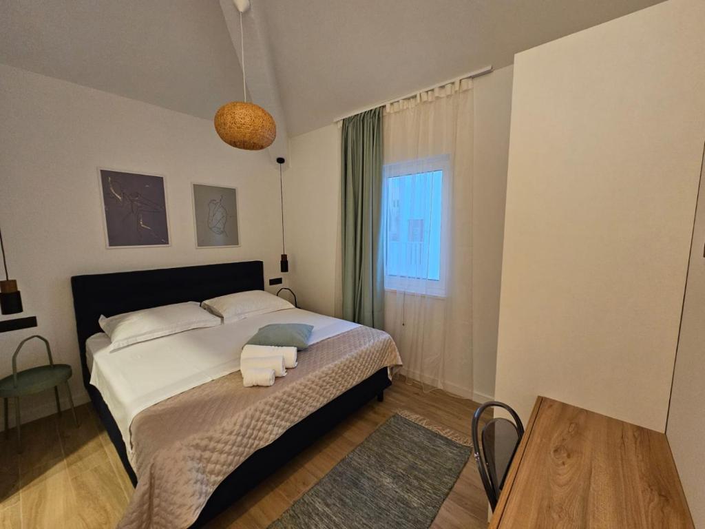 a bedroom with a bed with two towels on it at Villa LUX Apartments in Rogoznica