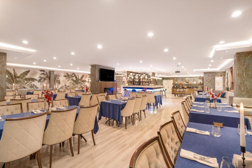 a dining room with blue tables and chairs at GRAND ANİ HOTEL in Kars