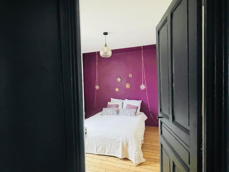 een slaapkamer met een bed met een paarse muur bij Confort - 4 pers - WIFI - plage à 400 m in Berck-sur-Mer