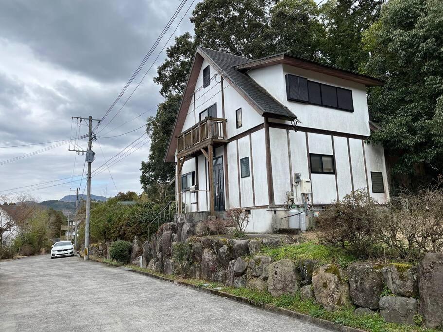uma casa branca na berma de uma estrada em 山樹荘 em Amagase