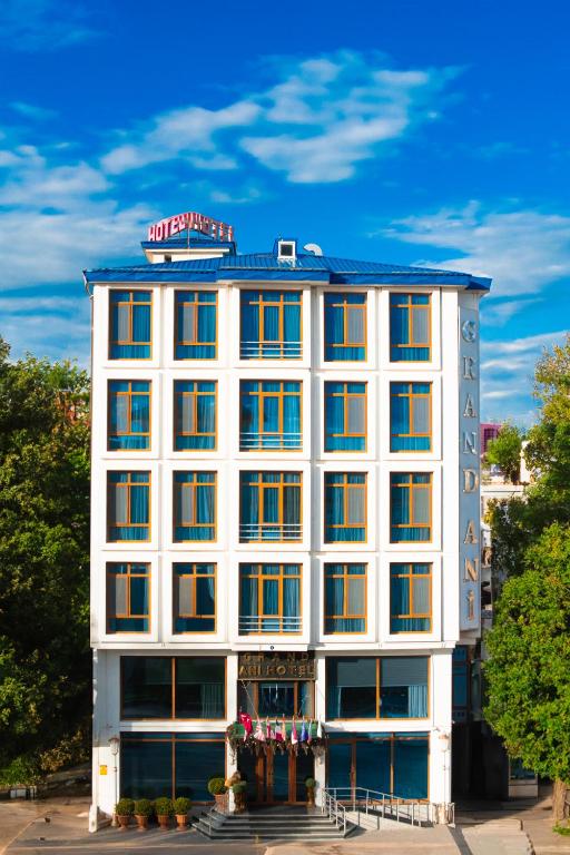 Un edificio blanco con un cartel encima. en GRAND ANİ HOTEL, en Kars
