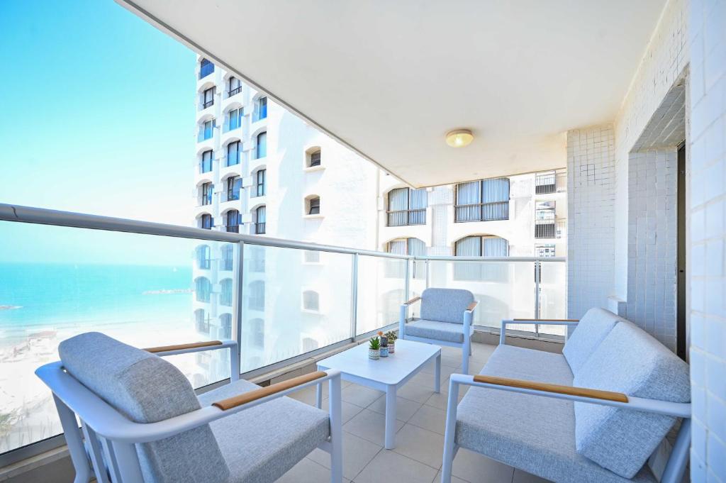 d'un balcon avec des chaises et une table offrant une vue sur l'océan. dans l'établissement Elegant Sea View at Orchid Hotel by HolyGuest, à Tel Aviv