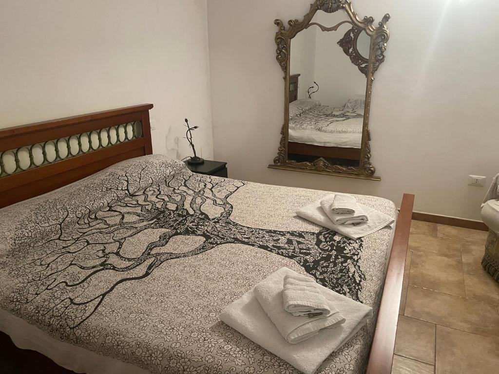 uma cama num quarto com um espelho e toalhas em Casa vacanze vicino Otranto em Giurdignano