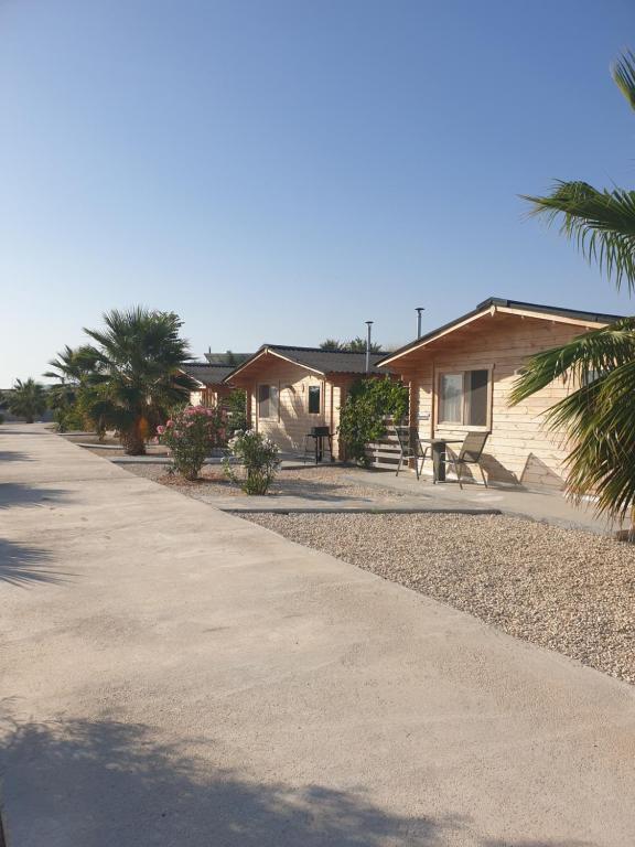eine Reihe von Cottages am Strand mit Palmen in der Unterkunft Casa de la Vida Liebetruth A in Aspe