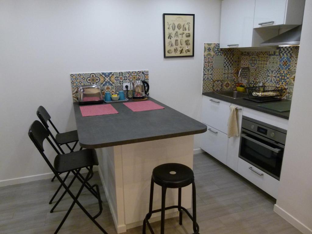 eine kleine Küche mit einer Theke und einem Herd in der Unterkunft Appartement Cœur de Ville - Saint Germain en Laye in Saint-Germain-en-Laye