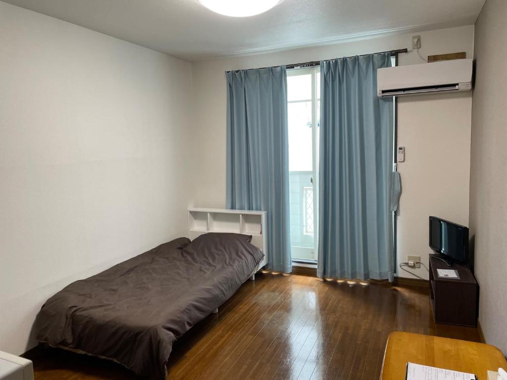 um quarto com uma cama e uma grande janela em Chambord Kyomachi 205 - Vacation STAY 69095v em Kumamoto