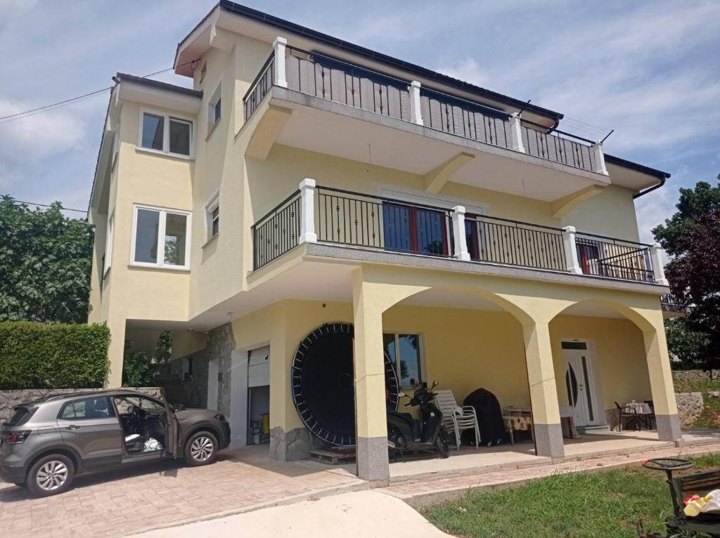 a house with a car parked in front of it at Apartman Mimi in Matulji