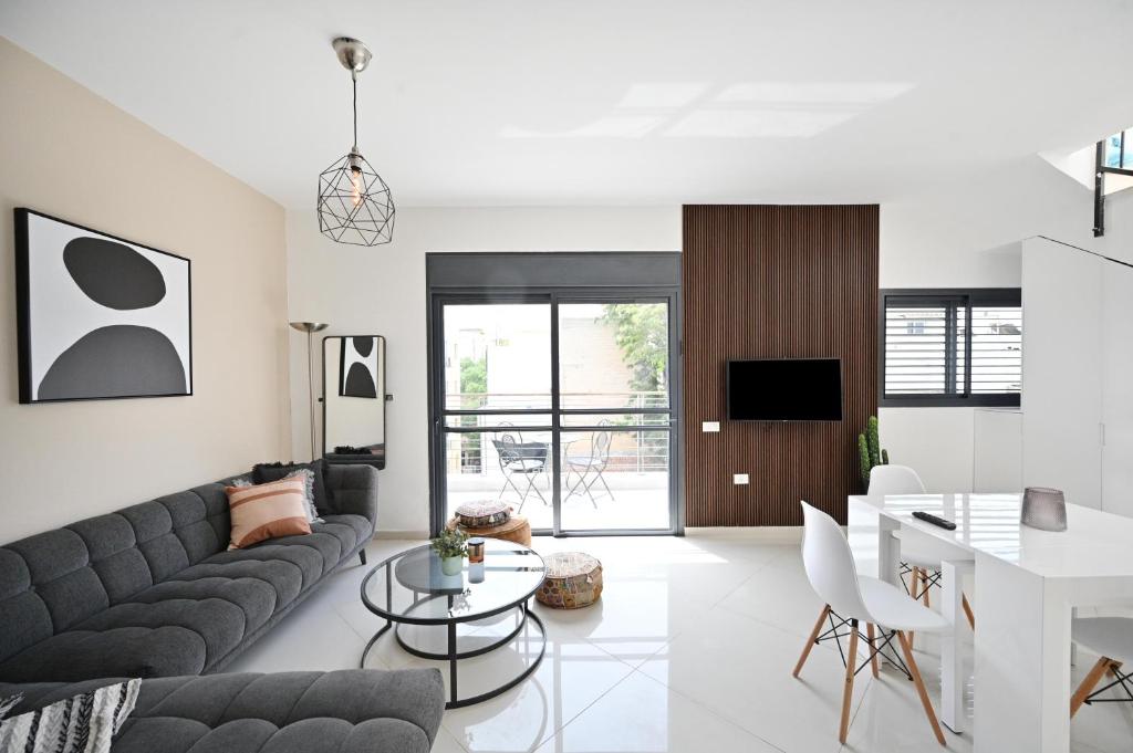 uma sala de estar com um sofá e uma mesa em Modern 3BR Duplex near BograshovBeach by HolyGuest em Tel Aviv