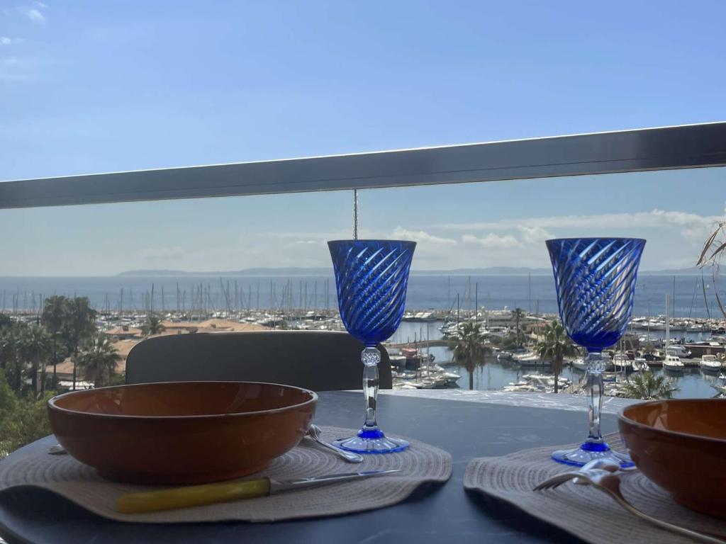 - une table avec deux verres à vin et une vue sur l'océan dans l'établissement Magnifique T3 Climatisé avec Vue sur Mer - FR-1-308-179, au Lavandou