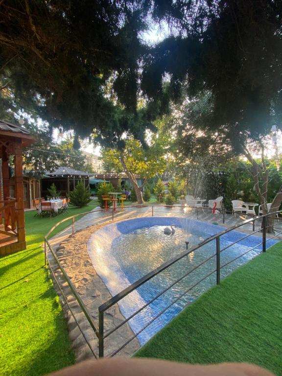 a pool with a fence around it in a yard at Damla Hotel Baku in Baku