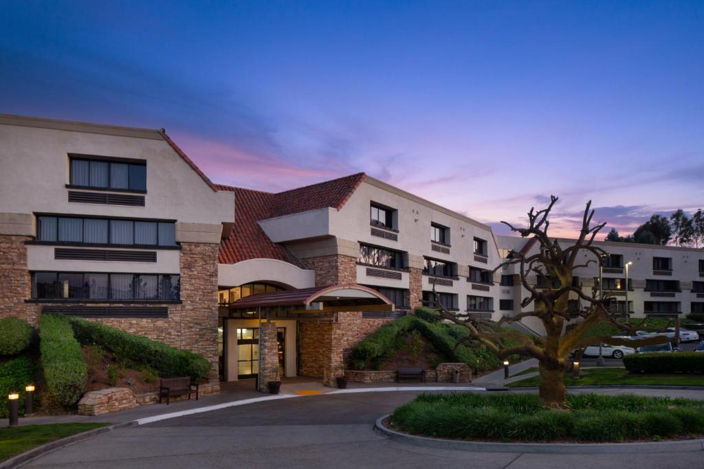 ランチョ・バーナードにあるCourtyard by Marriott San Diego Rancho Bernardoの木が目の前に建つホテルの建物