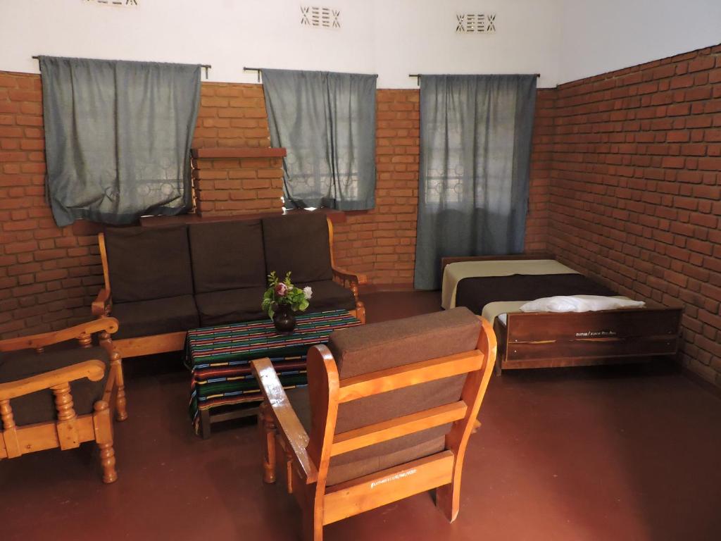 a living room with furniture and a brick wall at Perigrin Rest House in Karatu