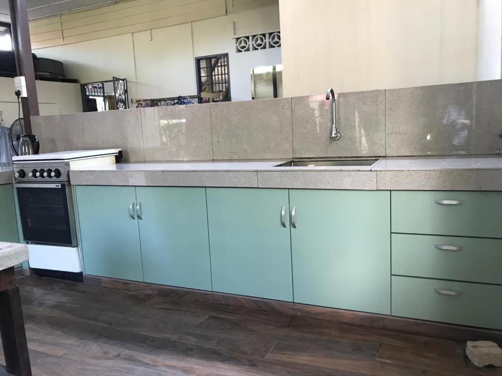 una cucina con armadi blu e lavandino di Yi Tong Nian Home Stay a Sitiawan