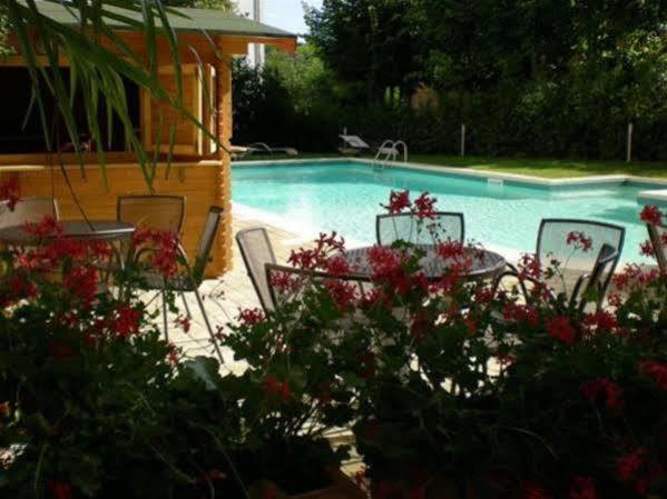 a swimming pool with chairs and a table with flowers at Hotel Mizar in Chianciano Terme