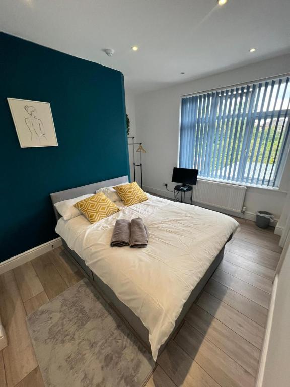 a bedroom with a large bed with a blue wall at Barnet Studios in New Southgate
