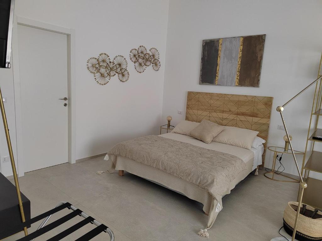 a bedroom with a bed and a painting on the wall at Dimore Gilas - Suite Golden in Monopoli