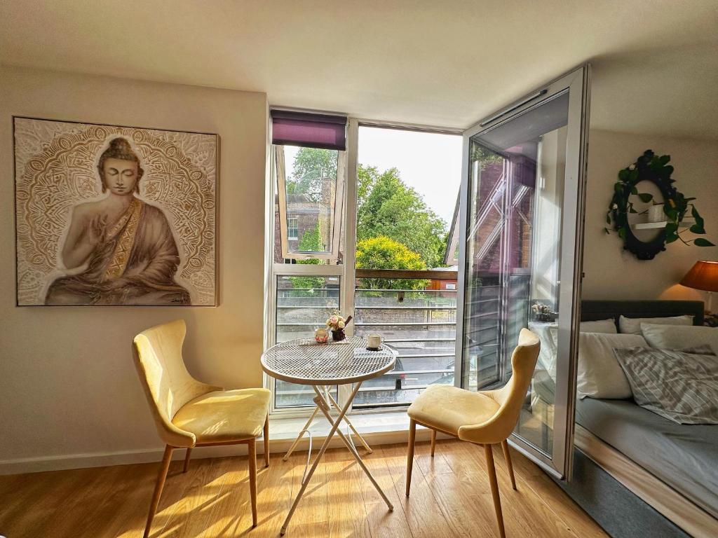 a room with a table and chairs and a window at Twickenham studio private apartment in Twickenham