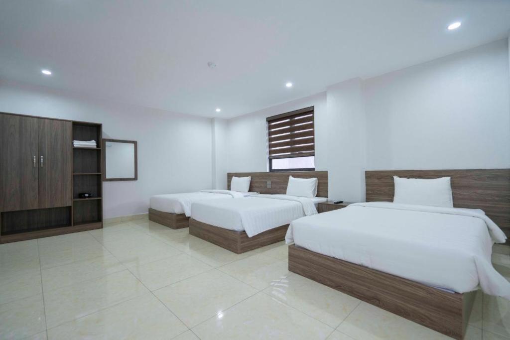 a hotel room with two beds and a tv at AURORA BÃI CHÁY HẠ LONG in Ha Long