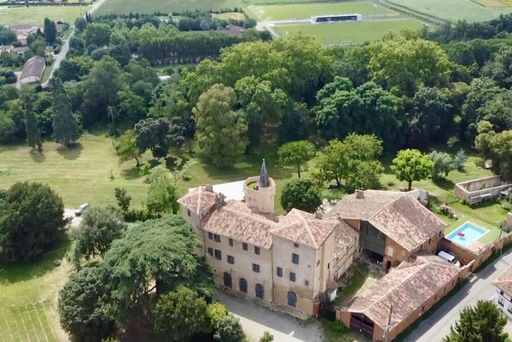 an aerial view of a large house with a church at Château de Fontanas, les Lauriers in Grisolles