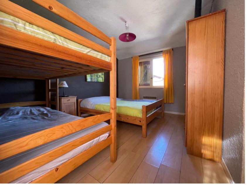 a bedroom with two bunk beds and a window at La Godille in Andon