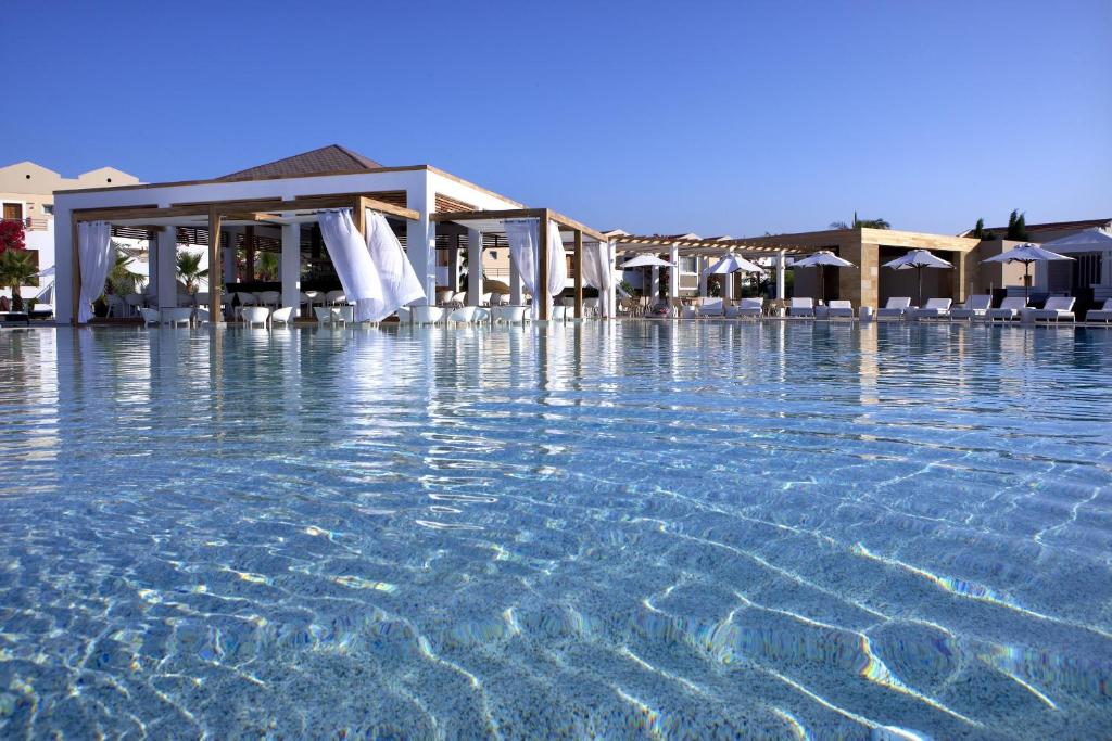 a swimming pool with chairs in the water at Pelagos Suites Hotel & Spa in Kos