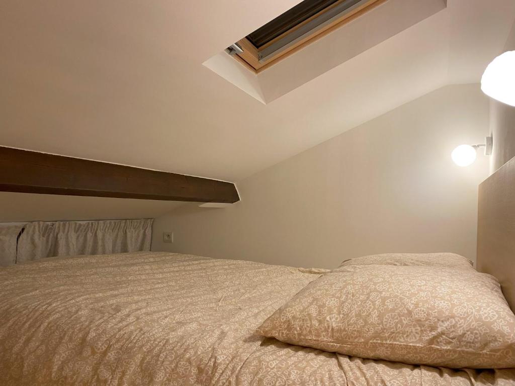 1 dormitorio con 1 cama con colcha blanca en The Little Oak - tiny house with bed on mezzanine & terrace - from 1 to 4 p Disney JO Paris, en Pomponne