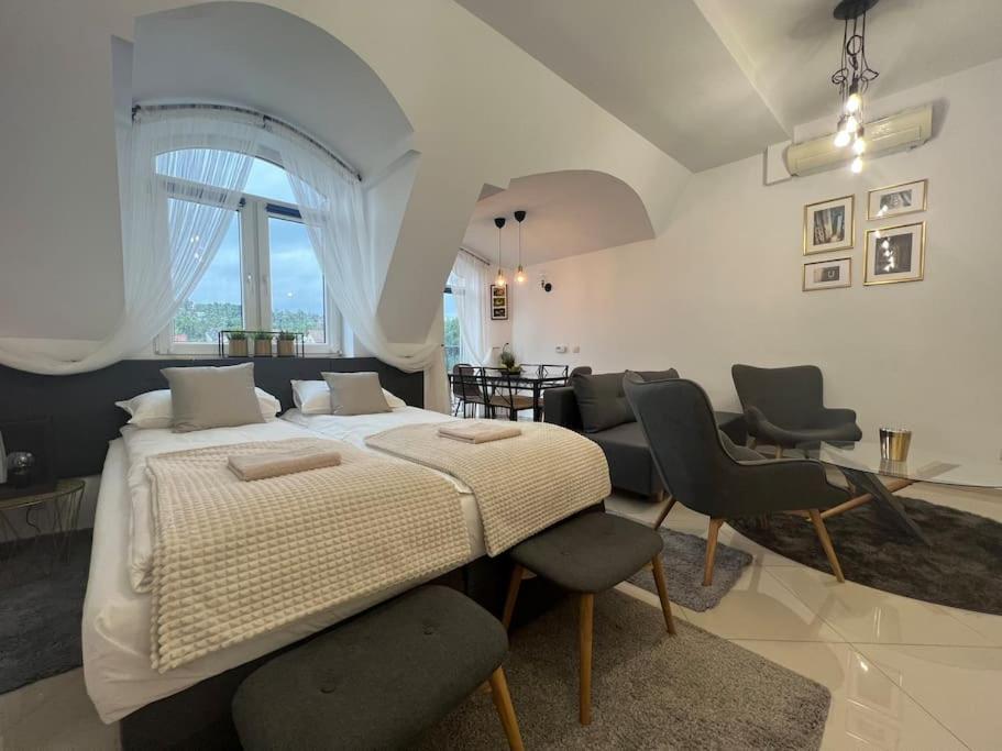 a bedroom with a large bed and chairs in it at Salt INN Apartments No 1 in Wieliczka