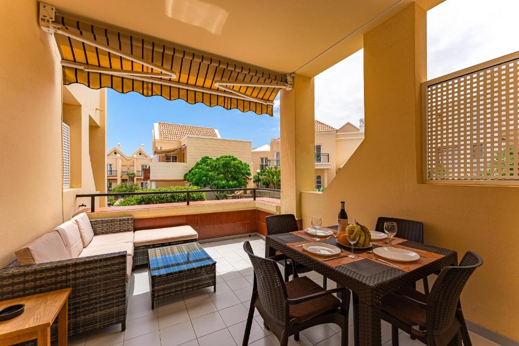 una sala da pranzo con tavolo e sedie sul balcone di Apartment in Yucca park ad Adeje