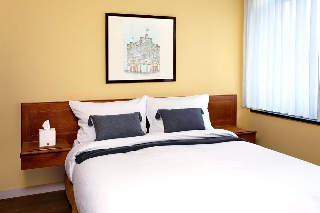 1 dormitorio con 1 cama blanca grande y 2 almohadas en Hotel Regina -Garni Köln en Colonia