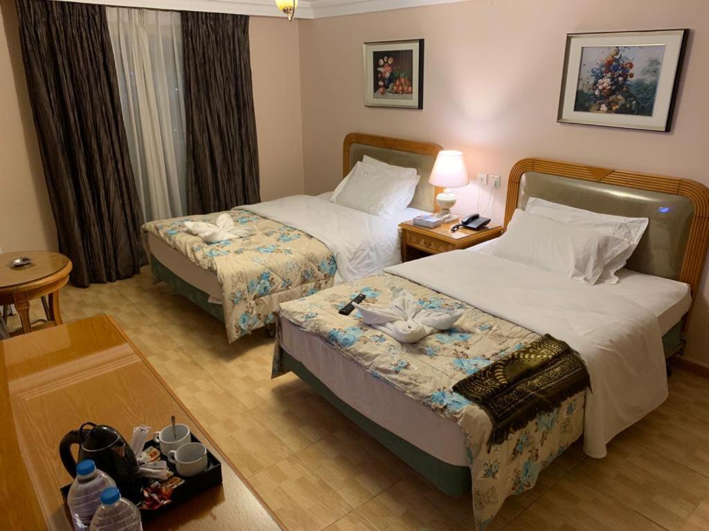 a hotel room with two beds and a table at Mas-wadi in Aqaba