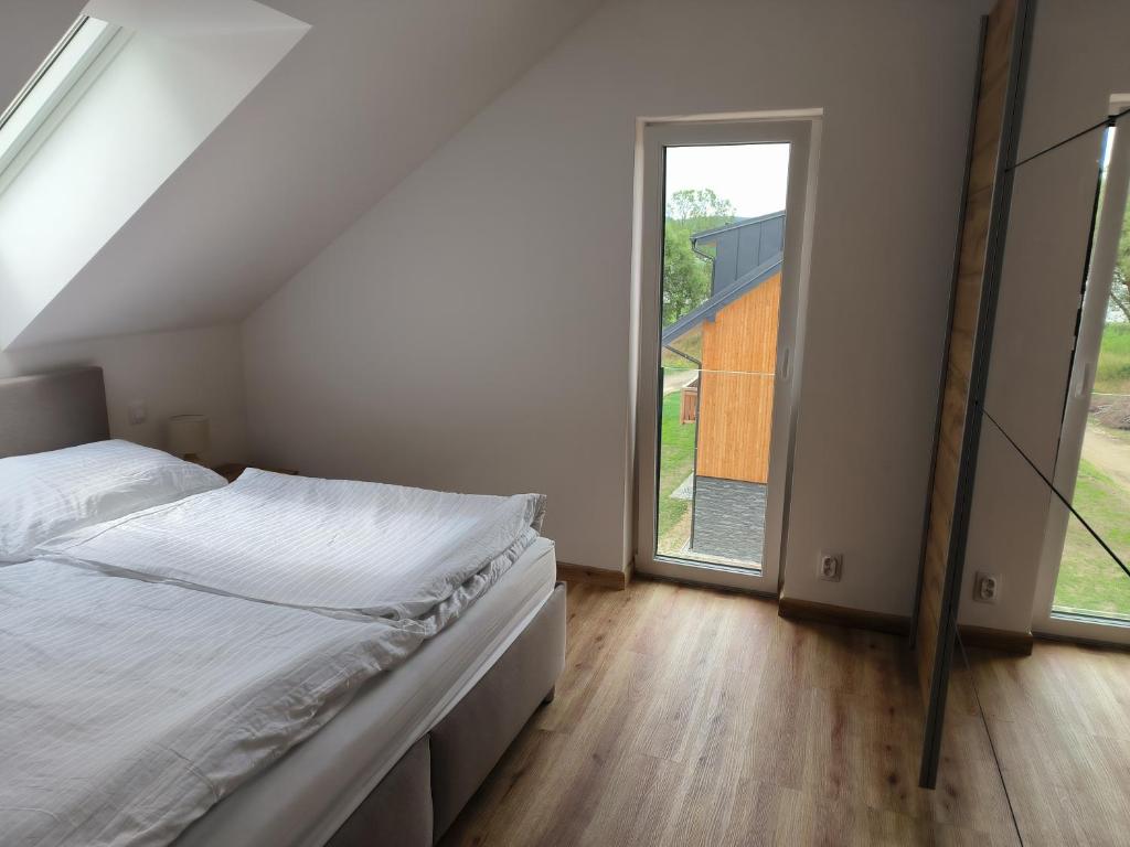 um quarto com uma cama e uma grande janela em Apartmán Černá v Pošumaví em Černá v Pošumaví