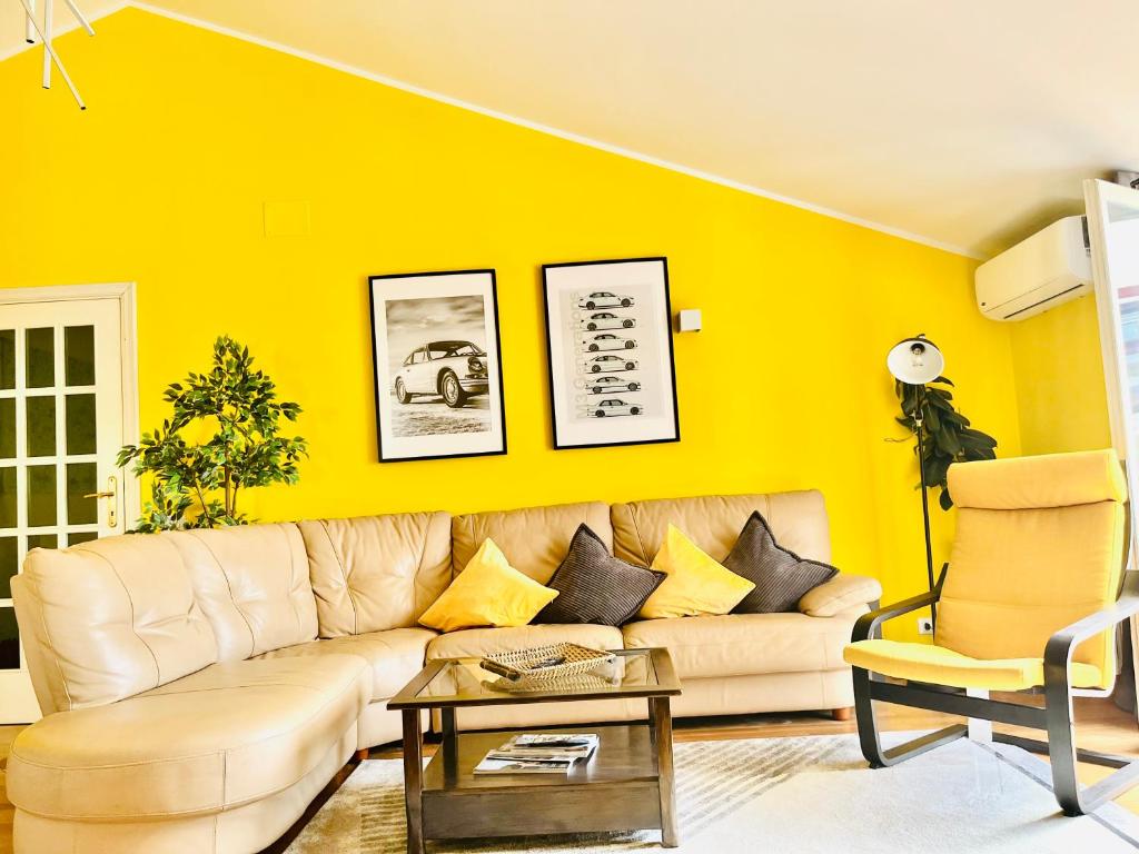 sala de estar con sofá y pared amarilla en Yellow House en Teramo