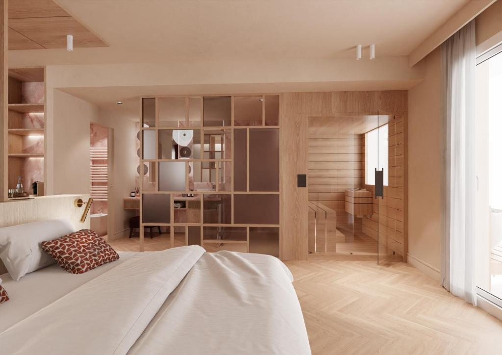 1 dormitorio con 1 cama blanca grande y escritorio en Baia del Mar Beach Boutique Hotel, en Lido di Jesolo