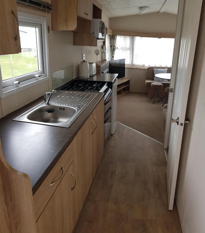 a kitchen with a sink and a stove at Daisie in Selsey