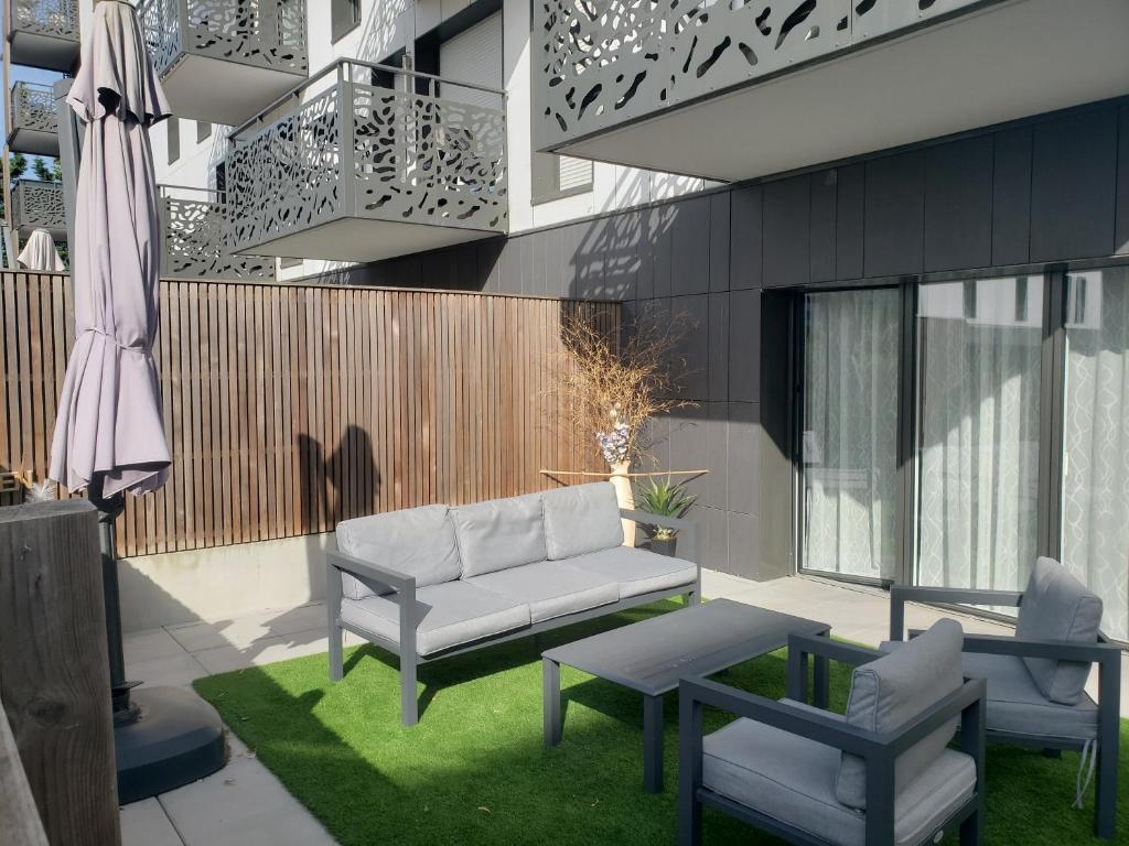 un patio avec un canapé, une table et des chaises dans l'établissement O'Sables, à Les Sables-dʼOlonne