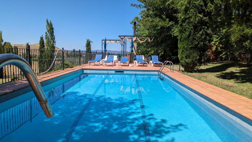 una piscina con un tobogán y sillas. en Casas Rurales Los Cortijos, en Alcaraz