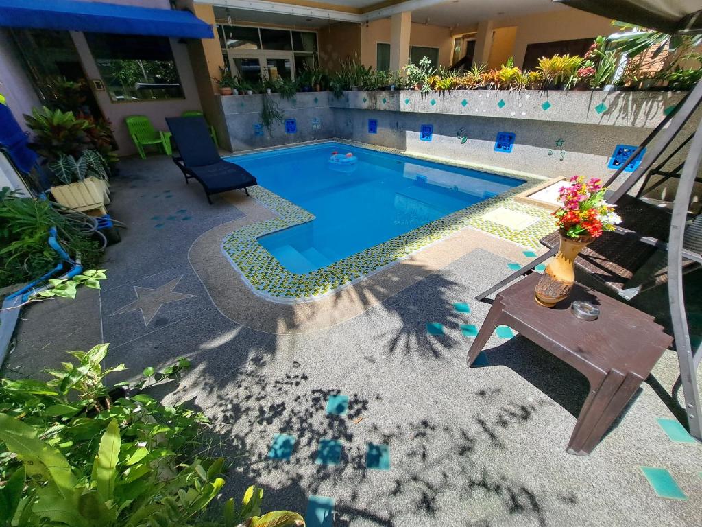 a swimming pool with a table and a bench next to it at Lily Holiday 百合假日 in Patong Beach