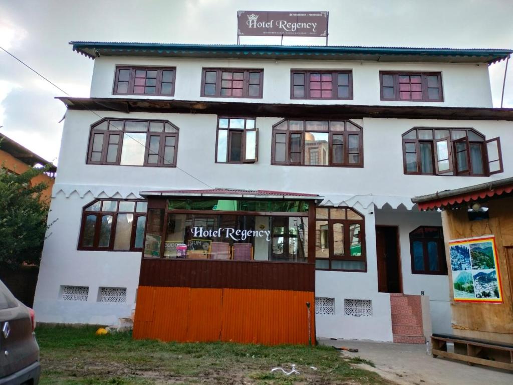 a white building with a store in front of it at HOTEL REGENCY in Srinagar