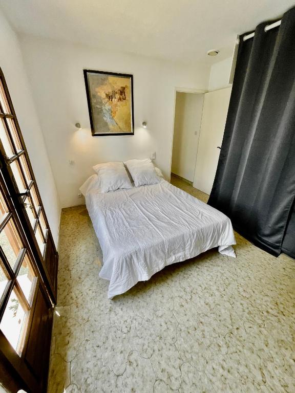 a bedroom with a large bed with white sheets at Maison de Bernard in Le Beausset
