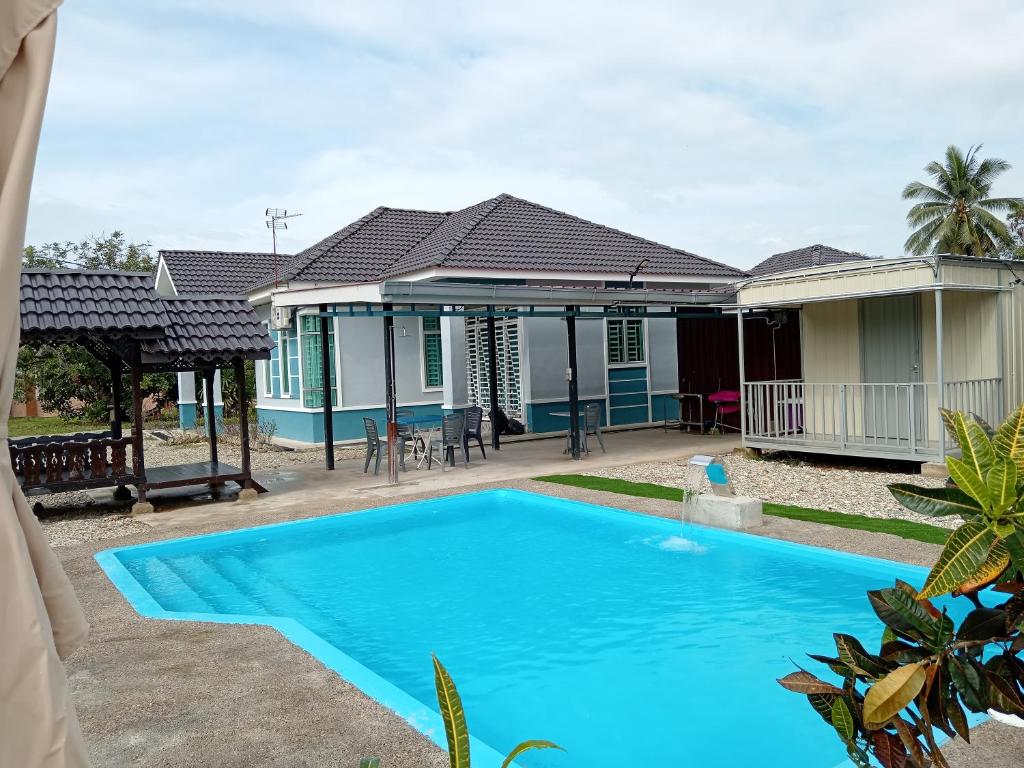 a villa with a swimming pool in front of a house at Homestay Pinang Tunggal in Sungai Petani