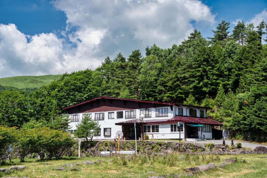 une grande maison blanche au milieu des arbres dans l'établissement Hütte Jil Shirakabako, à Chino