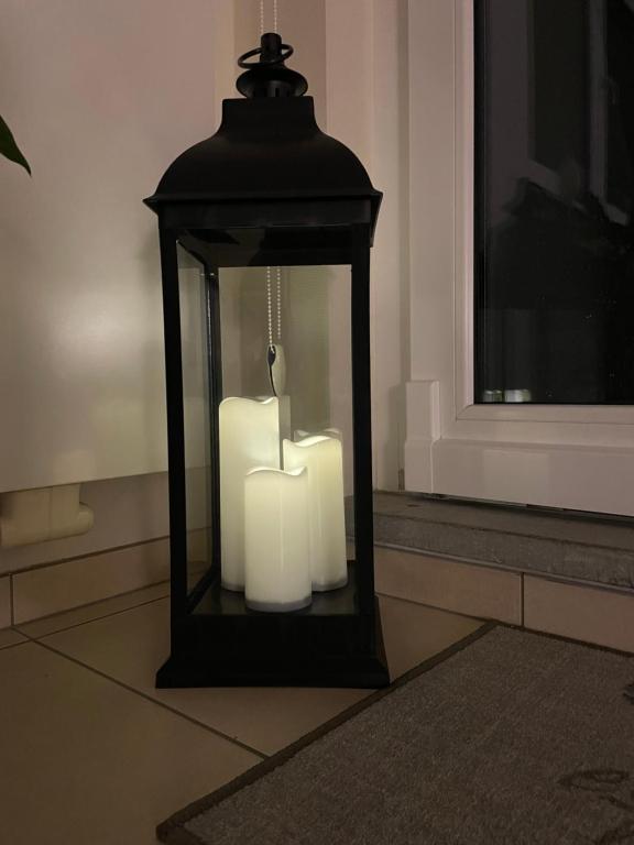 uma lanterna com duas velas brancas num quarto em Résidence Birdie em Jalhay