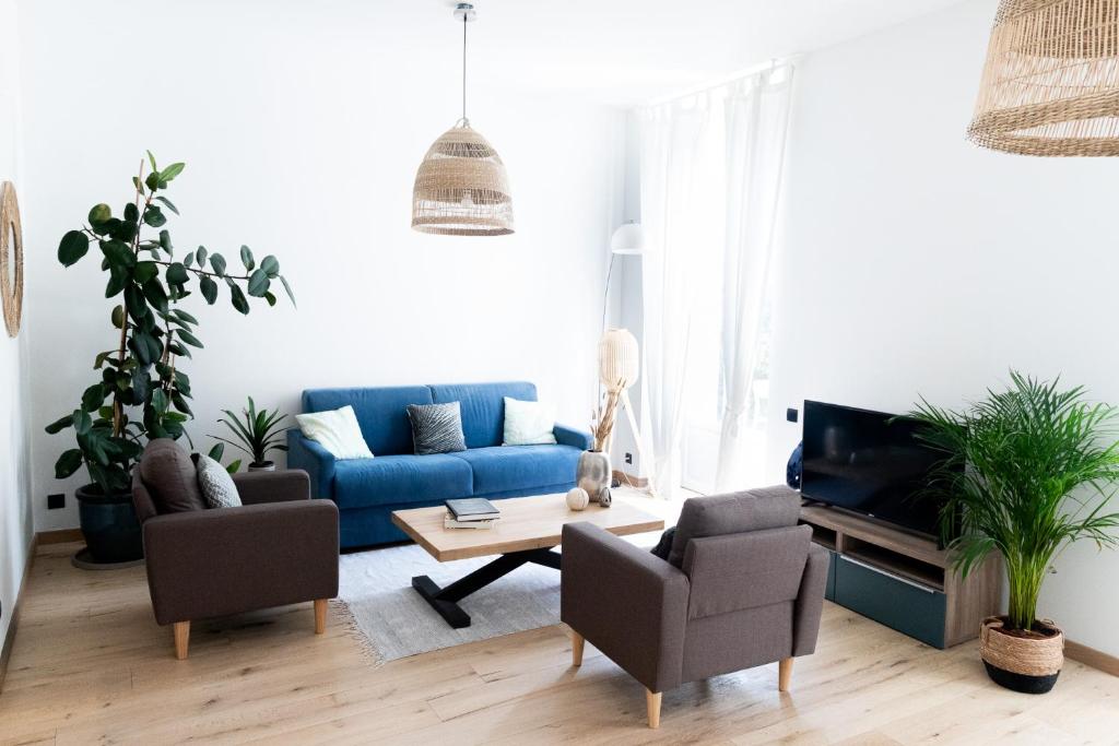 a living room with a blue couch and chairs at Sweett - Hotel Particulier Garden in Cannes