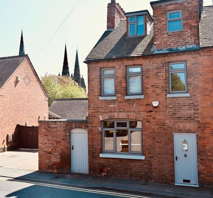 a brick house with two doors and a window at A character property close to Lichfield Cathedral in Lichfield